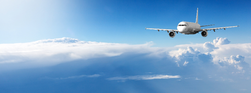 青い空をバックに飛ぶ飛行機